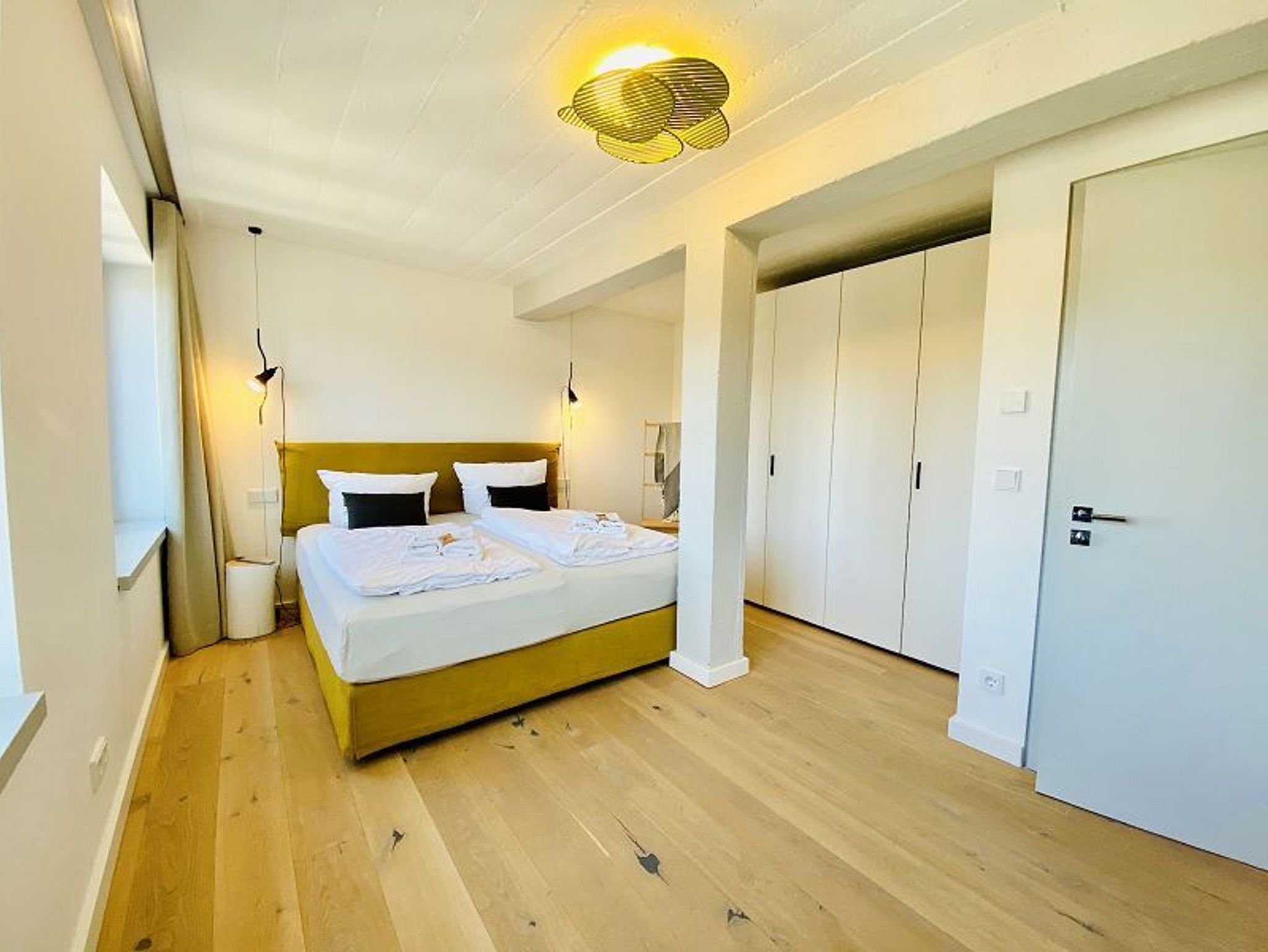 Das 1. Schlafzimmer mit einem Doppelbett und Kleiderschrank sowie mit Zugang zur Terrasse