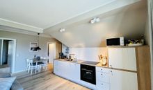 Der moderne offene Wohnbereich mit Essecke und Küche im Appartement Fienchen