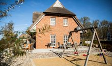 Blick vom Hof auf das Ferienhaus mit kleinem eigenen Spielplatz
