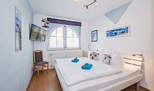 Schlafzimmer mit Doppelbett und TV