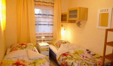 Schlafzimmer 2 mit zwei Einzelbetten, Schrank mit praktischer Ausstattung wie Schubladen und Spiegel