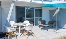 hochwertige Liegestühle auf der möblierten Terrasse mit Garten