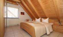 Schlafzimmer mit Doppelbett und Kinderbett