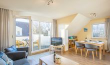 Der helle freundliche Wohnbereich mit Zugang zum möblierten Balkon