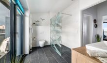 Badezimmer mit ebenerdiger Dusche und WC
