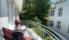 bestuhlter Balkon mit etwas Blick ins Grüne