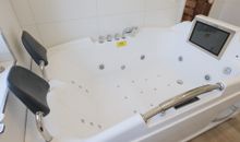 Badewanne mit Whirlpool und TV