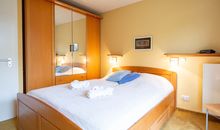 Das erste Schlafzimmer mit Doppelbett und Kleiderschrank