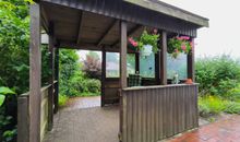 Überdachte Terrasse mit Gartenblick