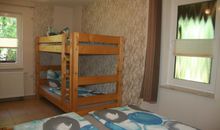 Schlafraum mit Doppelbett und Etagenbett