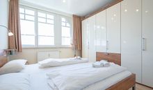 Das Schlafzimmer mit Doppelbett und großem Kleiderschrank